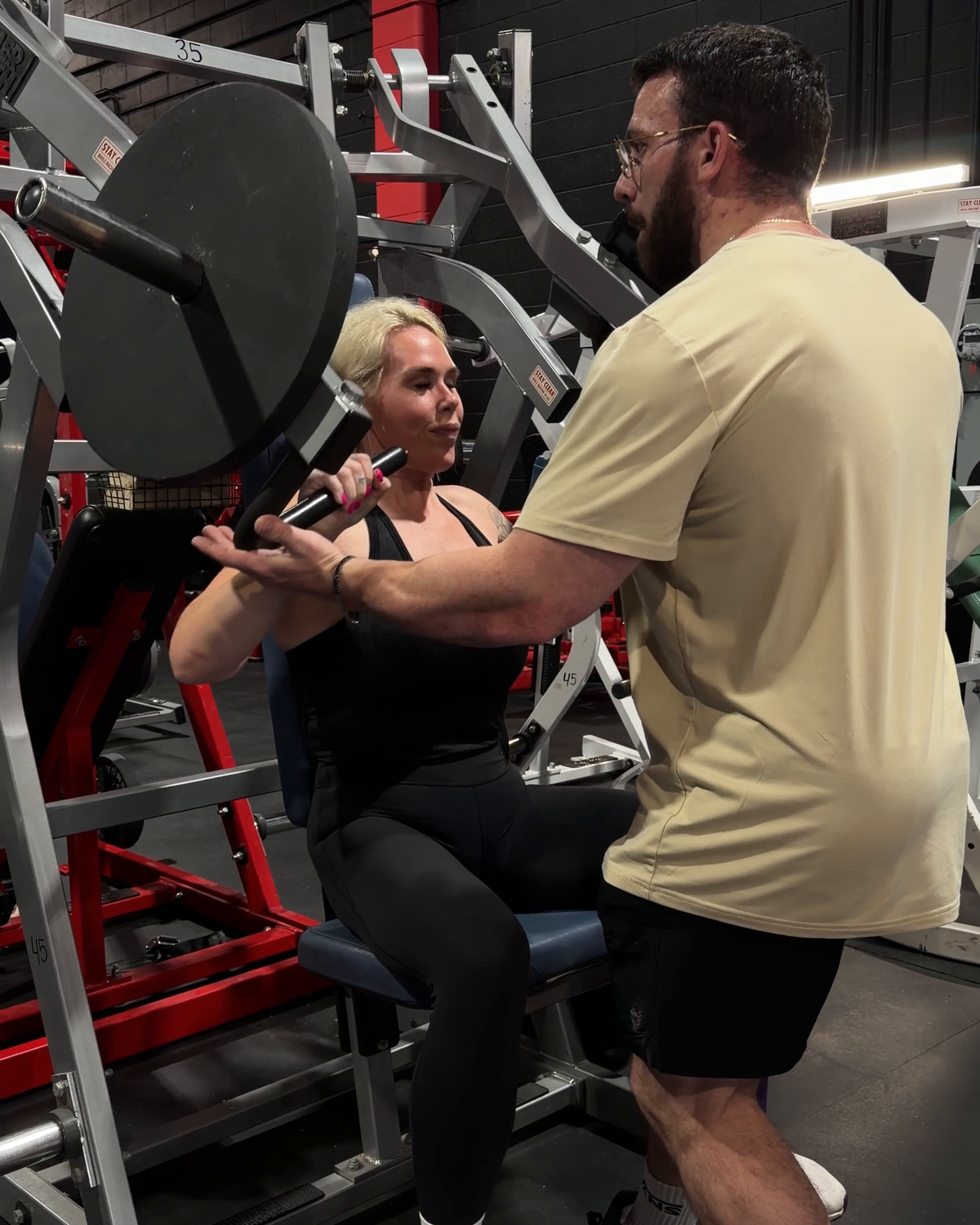 Tanner coaching a member on the chest press at Legacy Athletix