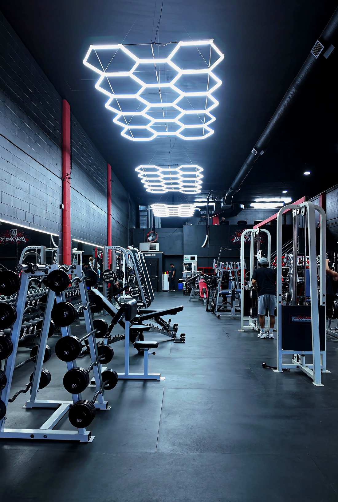The main training floor at Legacy Athletix looking down the aisle under the hexagon lighting