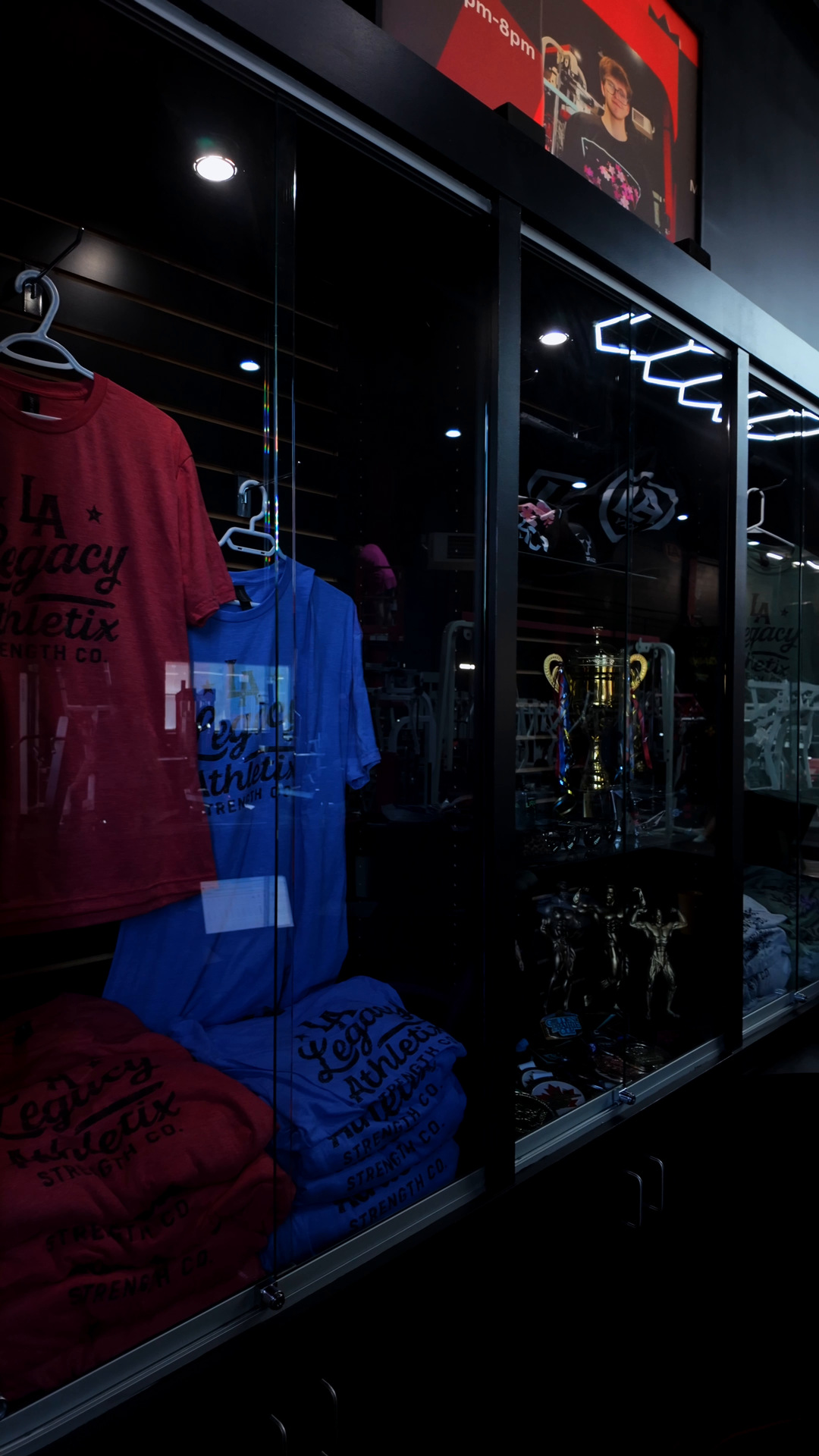 Bodybuilding trophies displayed in the case at Legacy Athletix
